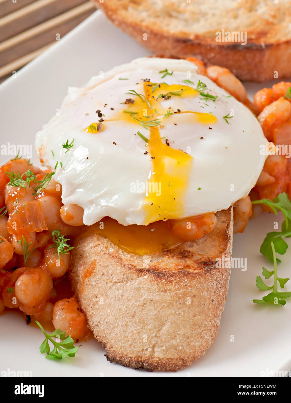 Breakfast poached egg with toast, baked beans with tomato sauce Stock