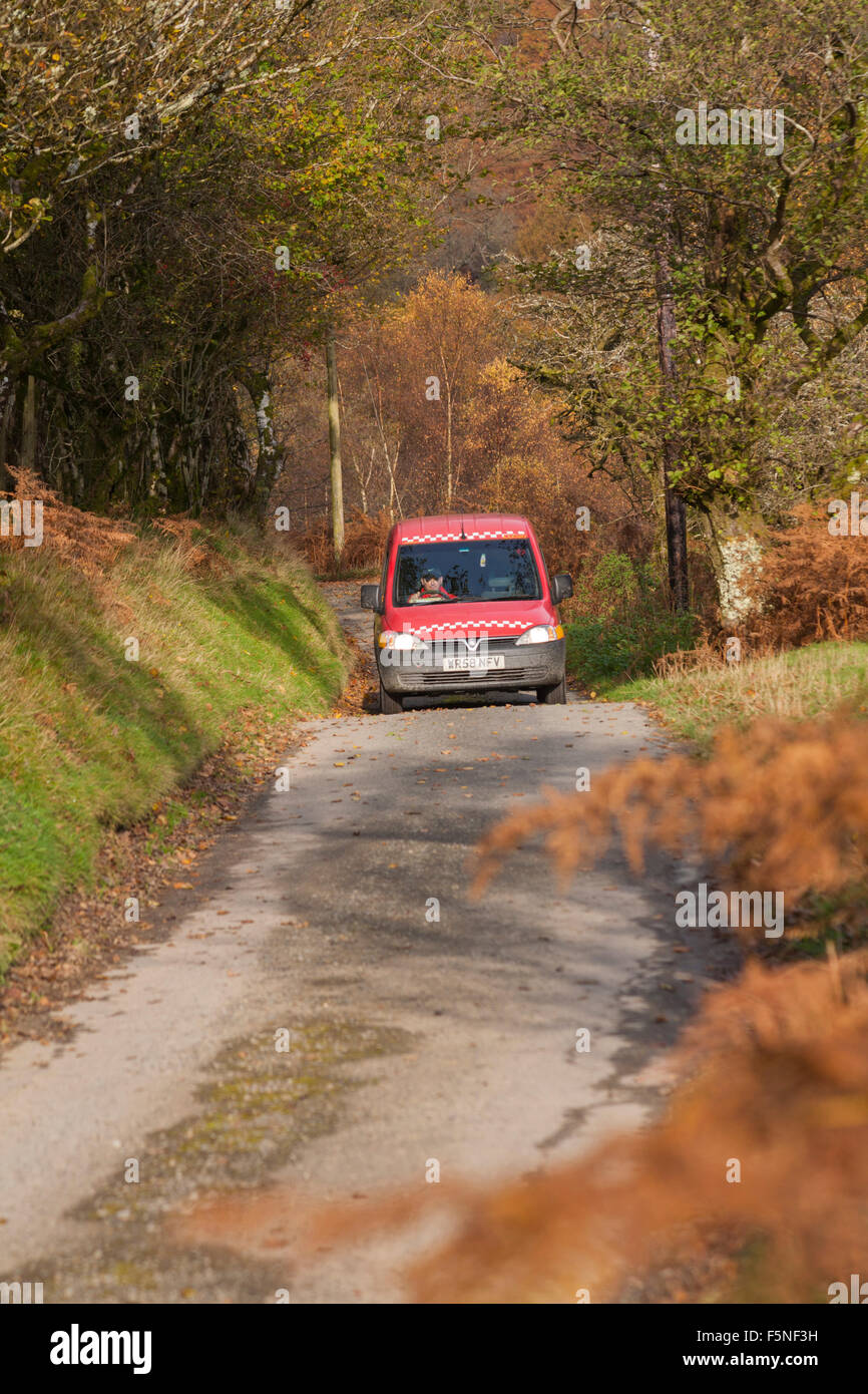 Royal Mail, Post Brenhinol, van driving along rural lane in Doethie Valley, at its confluence with the Upper River Tywi in Mid Wales, UK in November Stock Photo