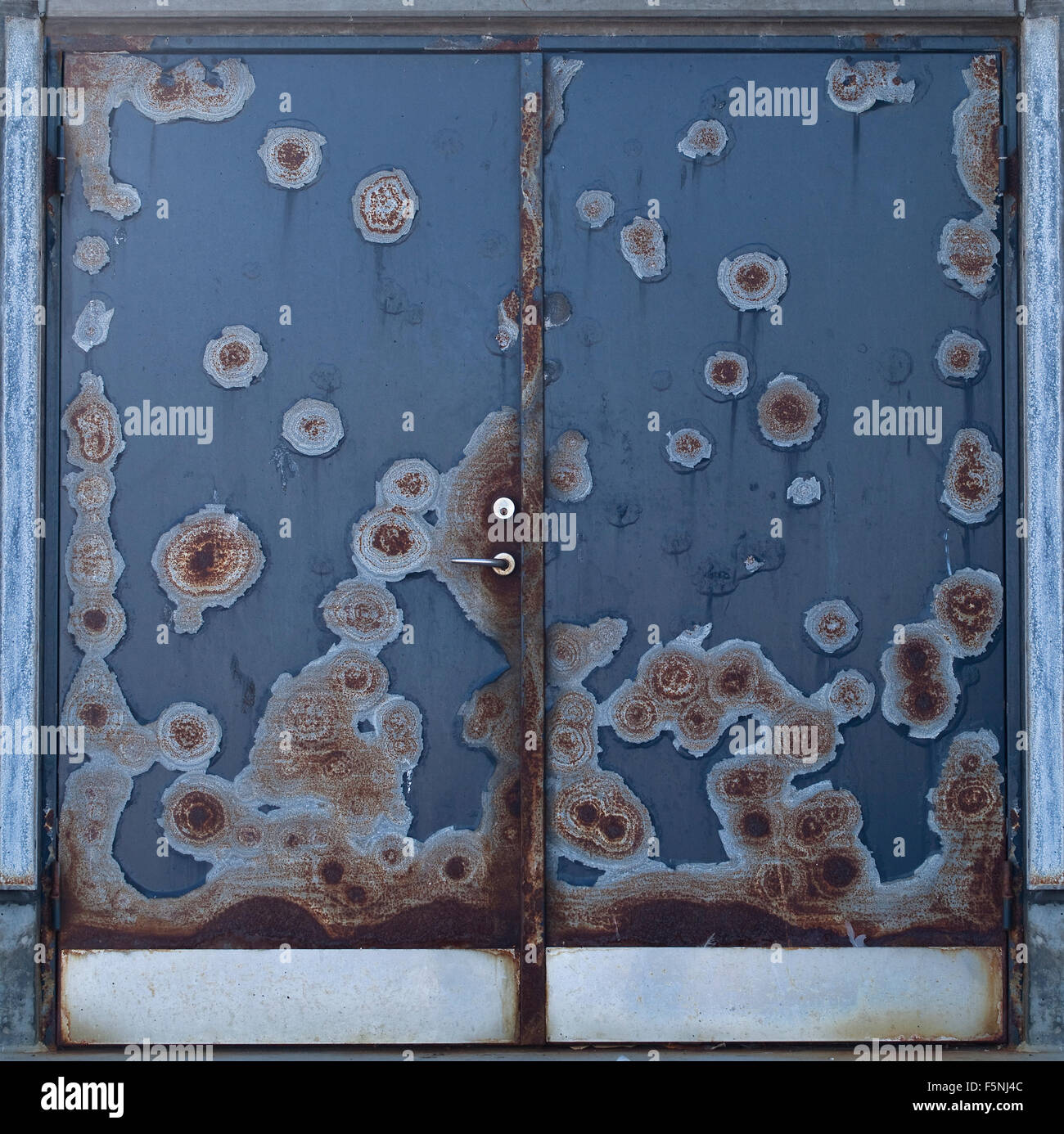 Doors to a commercial freezer have become battered over the years of use.The resulting damage is an interesting abstract pattern Stock Photo