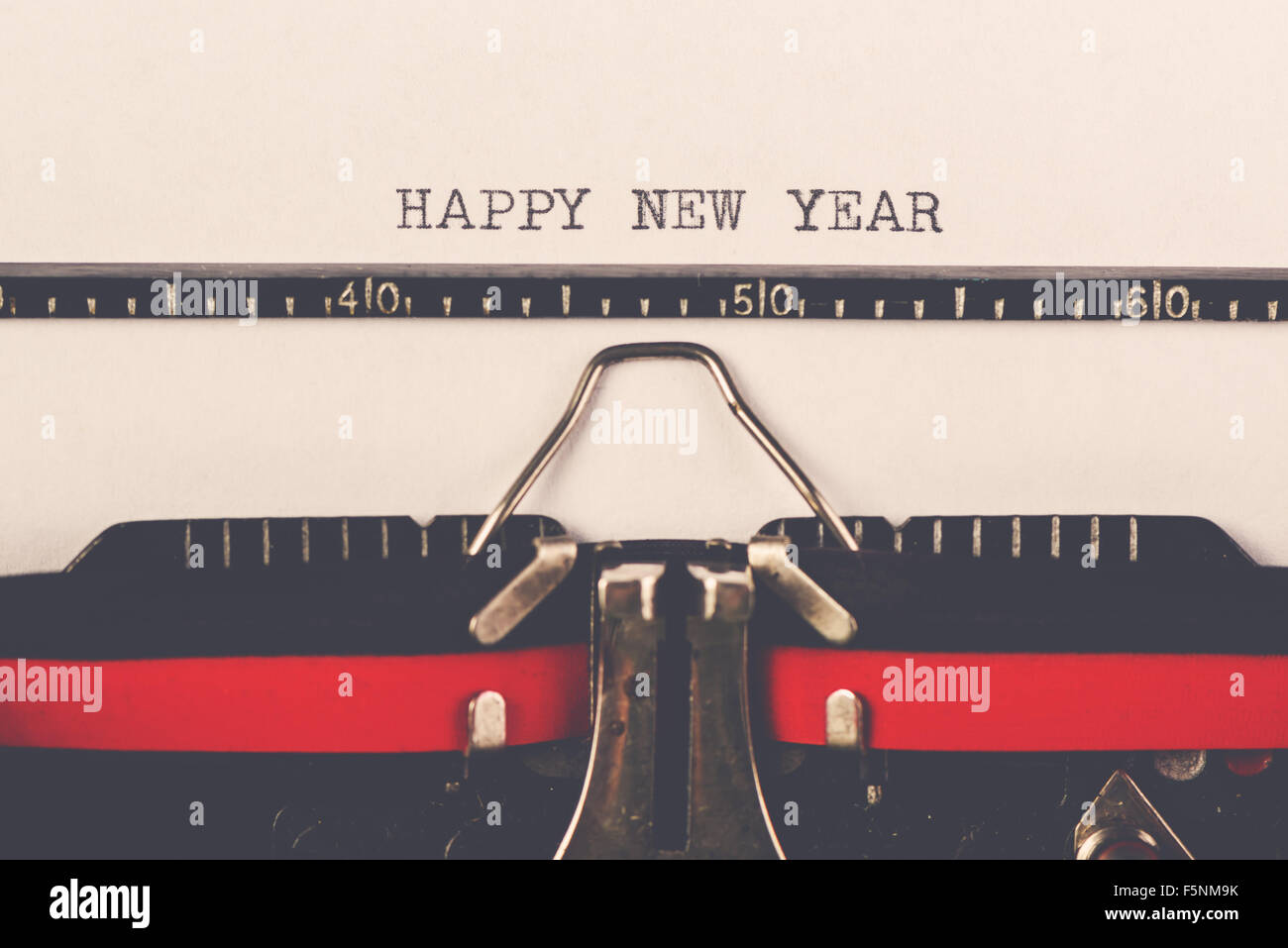 Happy New Year on old typewriter machine, hipster lifestyle holiday letter and greeting card, retro toned, selective focus Stock Photo