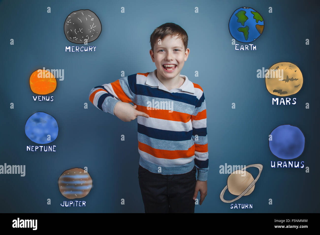 Teen boy points his finger down and laughs planets of the solar Stock Photo