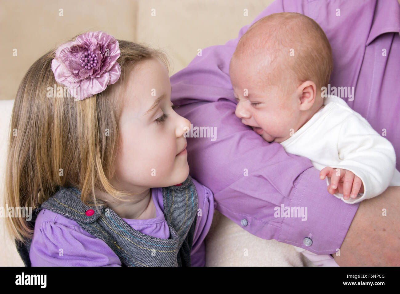 Newborn baby in her arms of his father and little girl Stock Photo