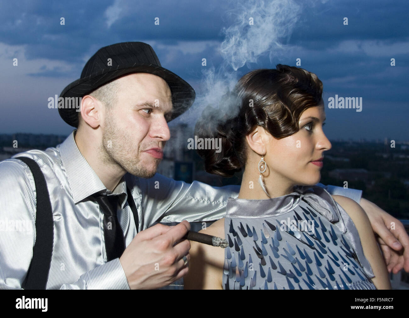 Smoking impudent gangster with retro girl Stock Photo