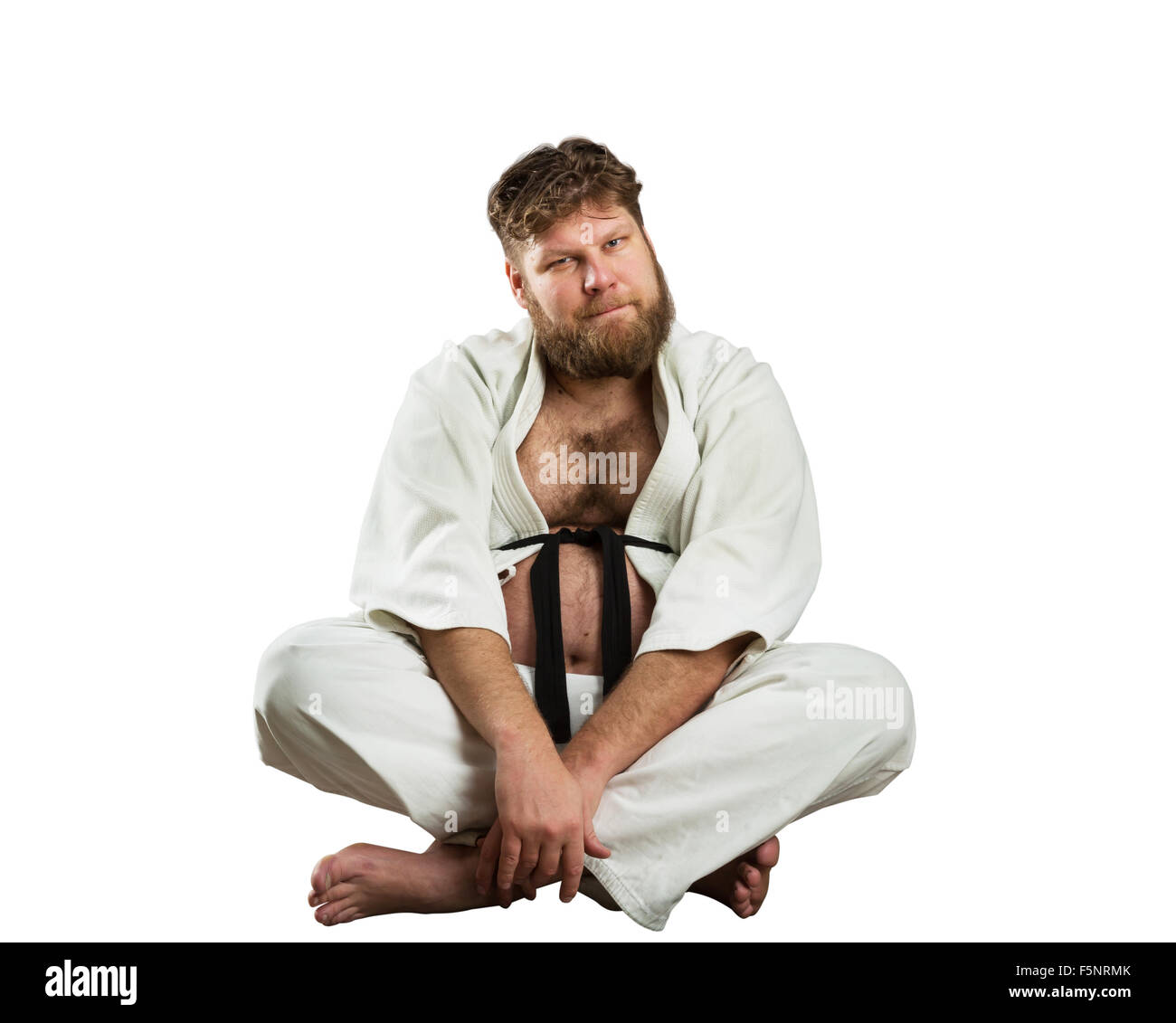 Fat karate fighter sits with crossed legs over white Stock Photo