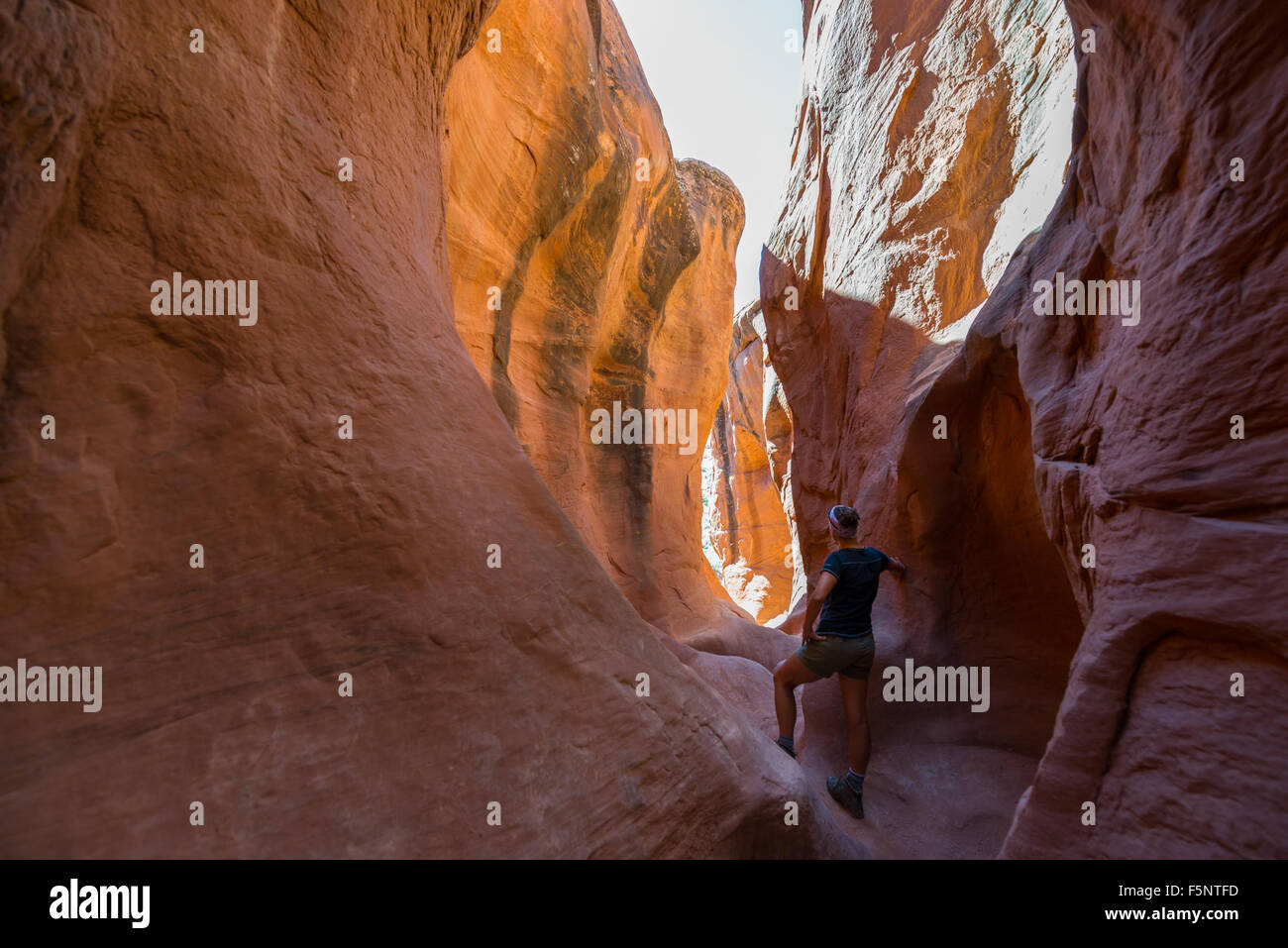 A woman admires the warm light in Peekaboo Gulch in the Escalante Canyons of Grand Staircase Escalante National Monument, Utah. Stock Photo