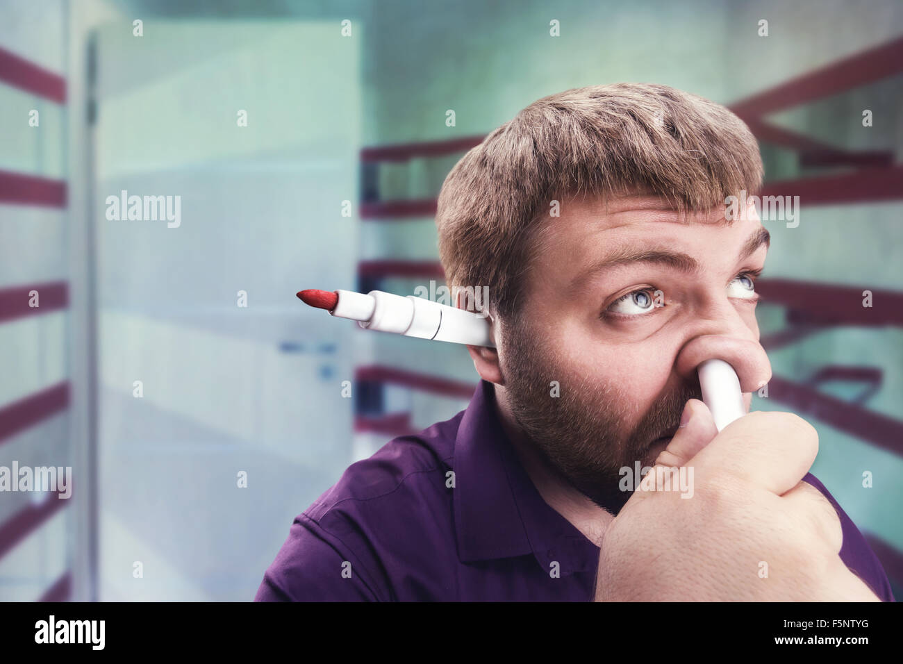 Strange bearded man with highlighter in the ear and in the nose Stock Photo
