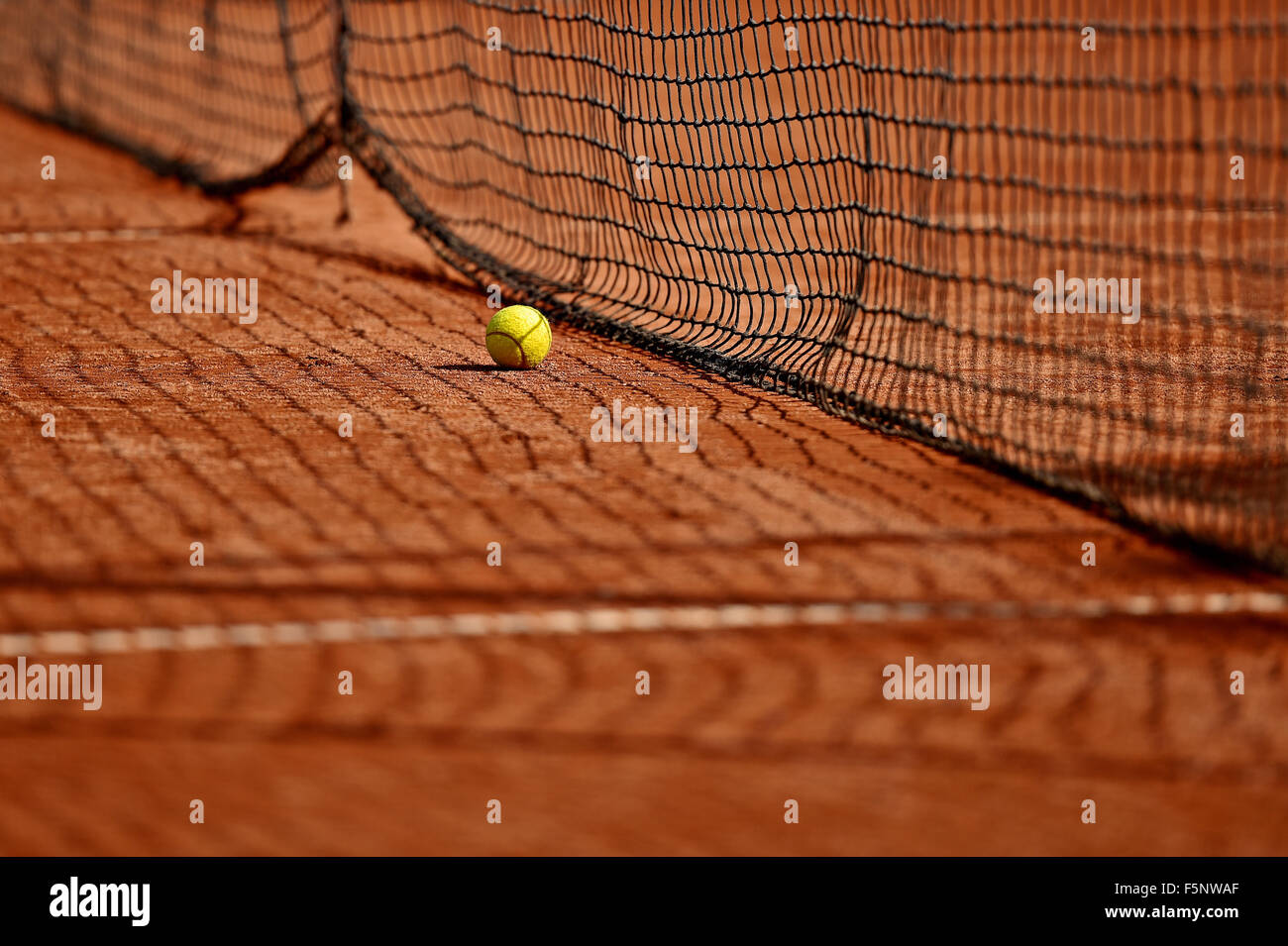 Detail shot with a tennis ball close to the net on a tennis clay court Stock Photo