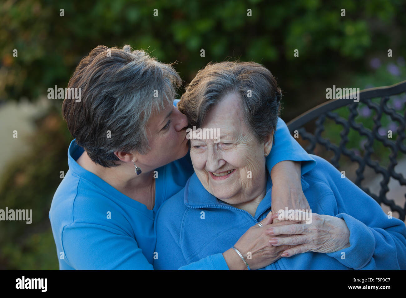 Daughter Kisses Mothers Forehead tenderly. Stock Photo