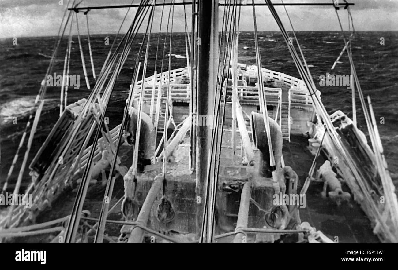 AJAXNETPHOTO.- 1942. NORTH ATLANTIC OCEAN. - CONVOY SHIP ICE BOUND - BRITISH MERCHANT SHIP M.V. TOLTEN, HER DECKS AND RIGGING BOUND IN ICE ON PASSAGE TO THE U.K.NOTE CARLEY FLOATS PORT AND STARBOARD IN THE RIGGING SHROUDS. PHOTO; RAY EASTLAND/AJAX  REF:42 1 Stock Photo