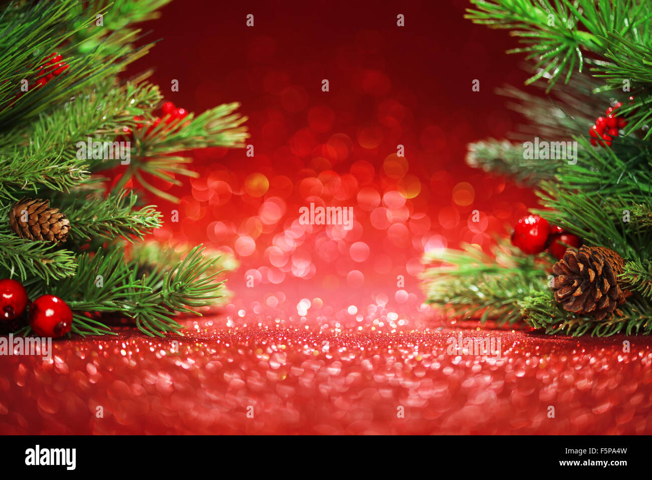 Christmas tree branches on glittering red background Stock Photo
