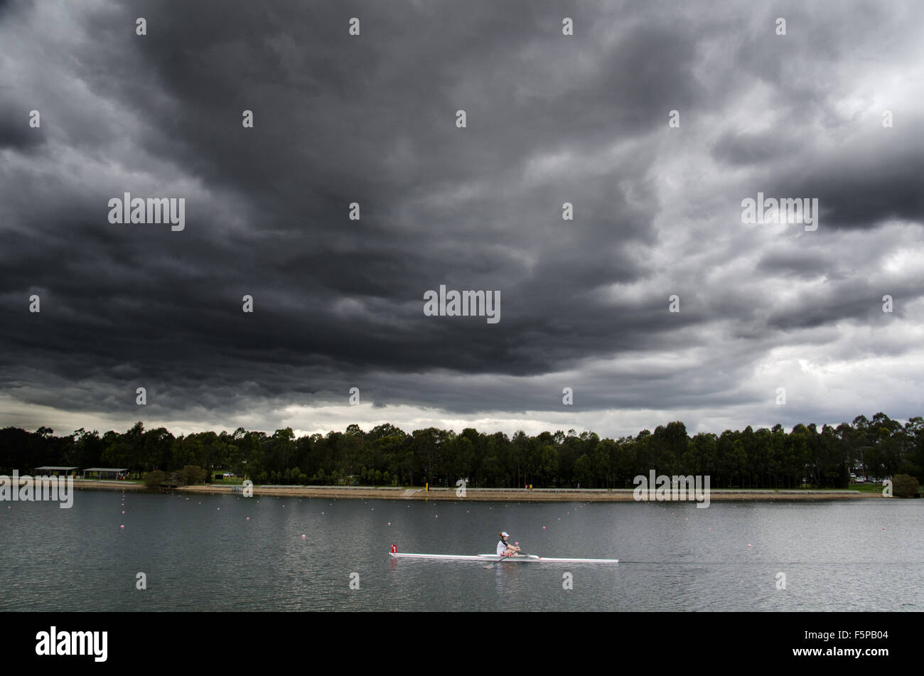 Rowers seen racing under a storm cloud at the Sydney International Regatta Centre. The Sydney International Regatta Centre was built for the 2000 Summer Olympics. Credit:  mjmediabox/Alamy Live News Stock Photo