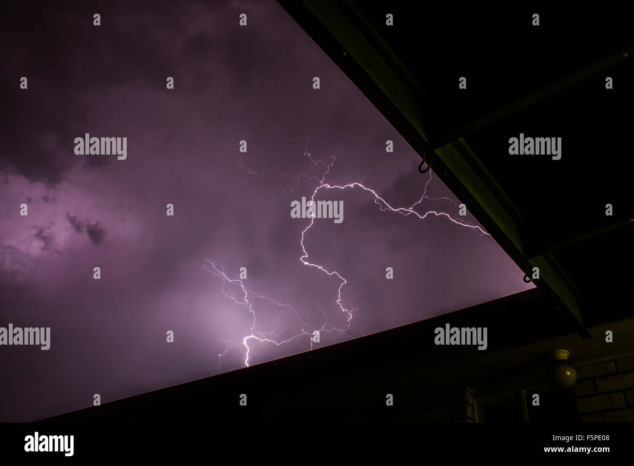 Lightning bolt strikes during thunder storm over a house in suburb ...