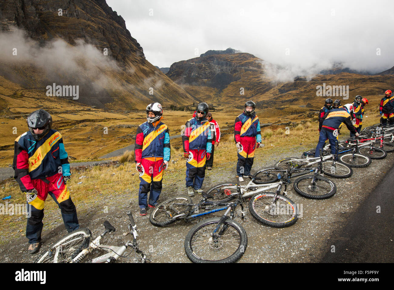 Tourists prepare to descend the infamous Death Road, near La Paz in Bolivia. It is reputedly the most dangerous road on the planet. A gravel track barely wide enough for two vehicles with drops of 3000 feet on one side. It has become a popular tourist trip to descend the road on mountain bikes. Stock Photo