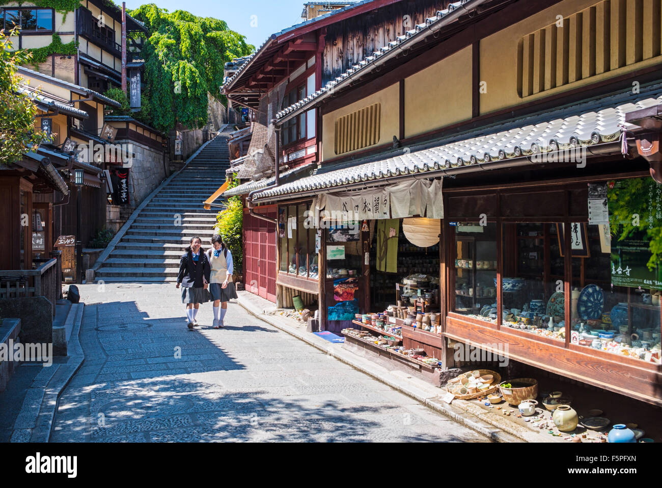 Two school girls laughing and walking alone Ninen-zaka and Sannen-zaka shopping streets in Kyoto, Japan Stock Photo