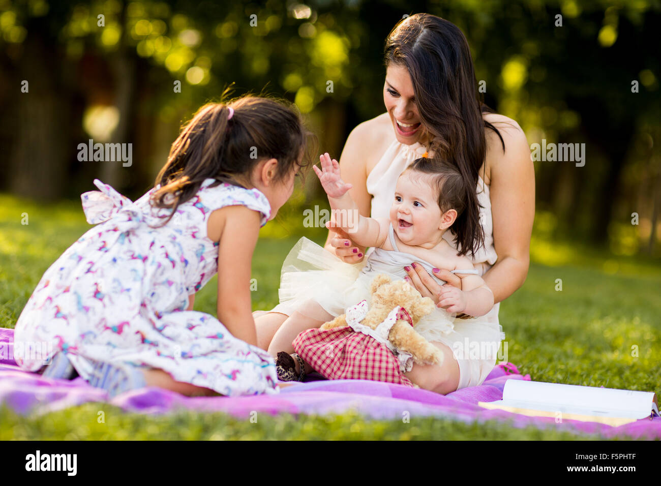 Little girl, baby girl and mother outdoor Stock Photo
