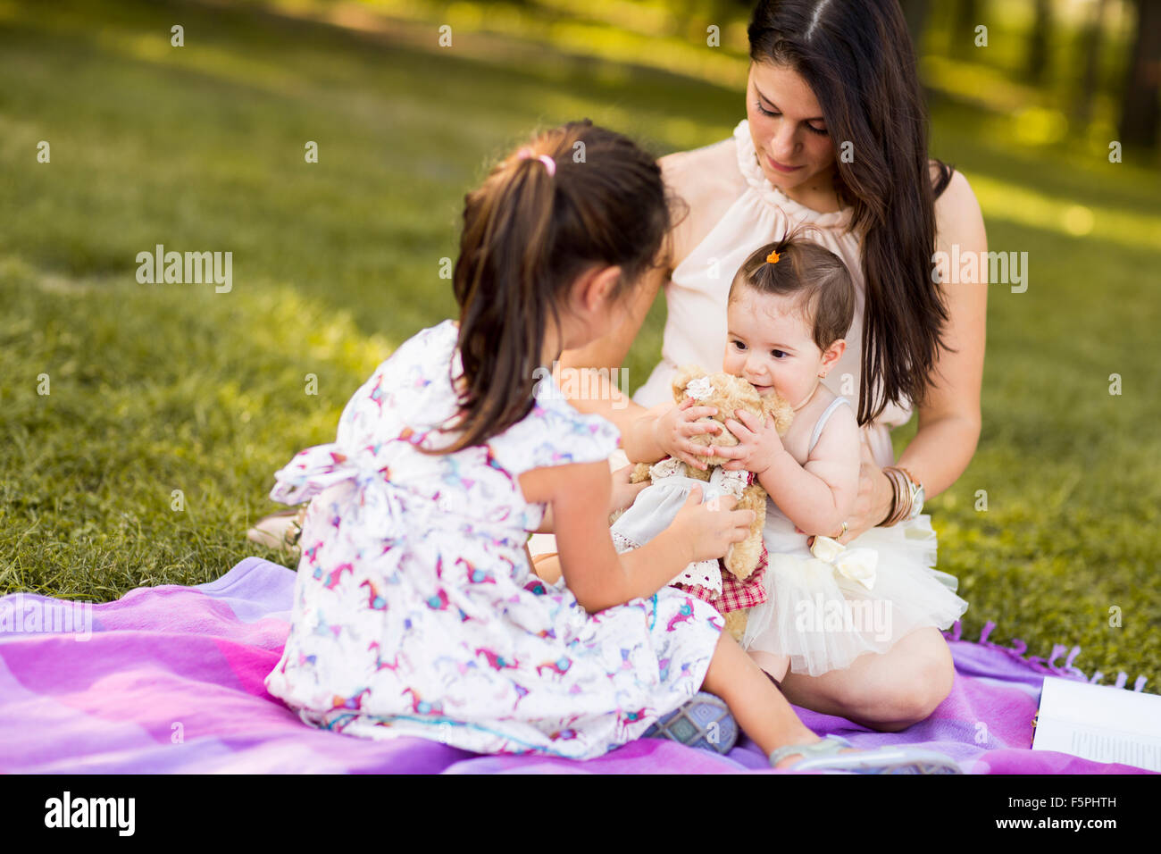 Little girl, baby girl and mother outdoor Stock Photo