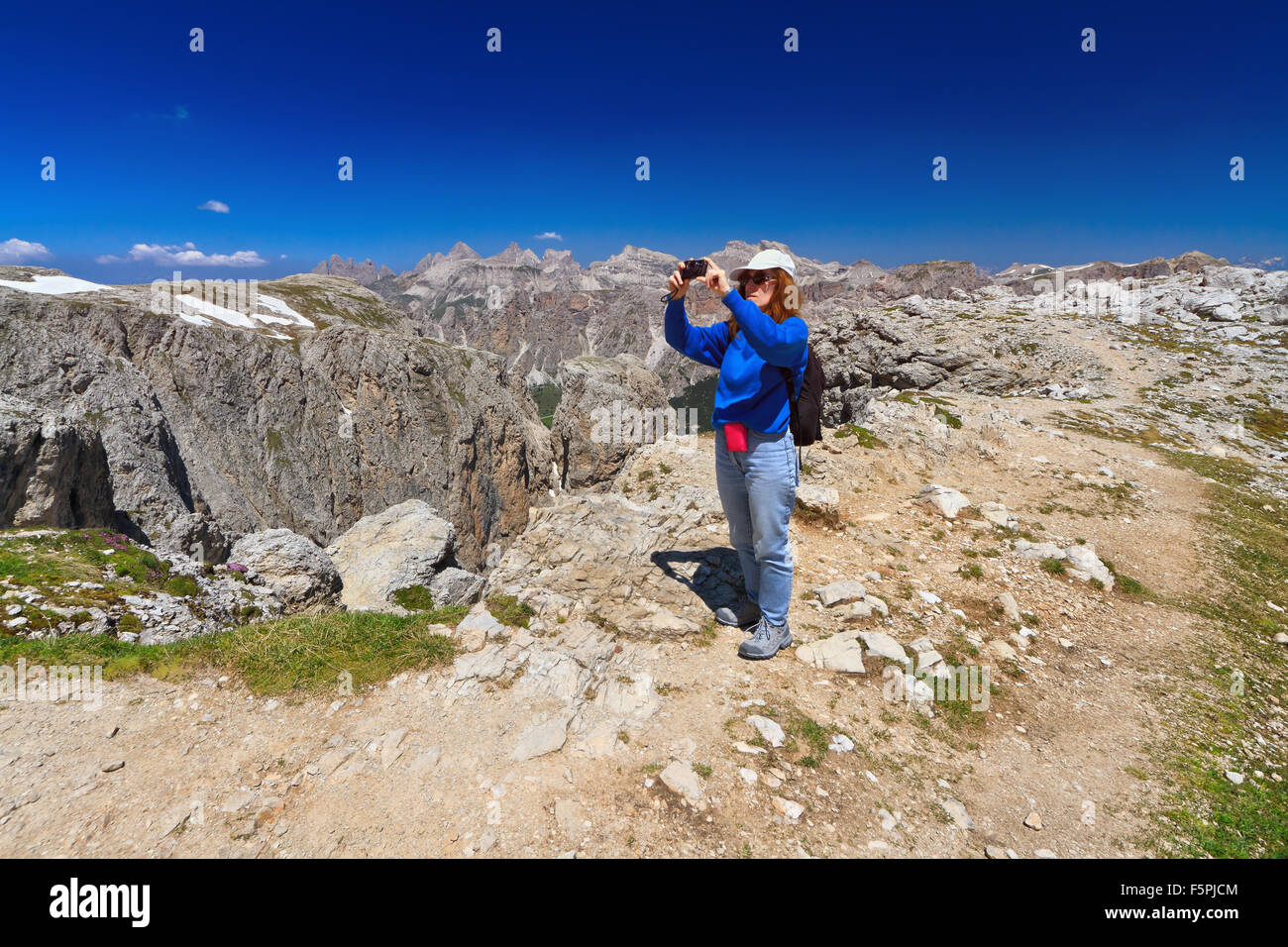 hiker take a picture from a scenic spot in Sella mount, Italian Dolomites Stock Photo
