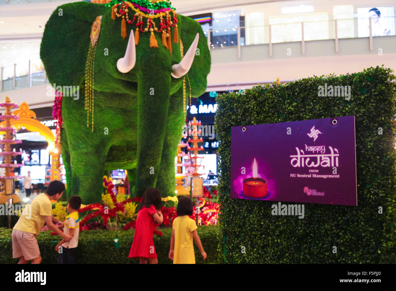 Kuala Lumpur, Malaysia. 8th Nov, 2015. Children curiously inspecting the Deepavali elephant statue, symbol of hindu Lord Ganesha at NU Sentral shopping mall in Kuala Lumpur Malaysia. This year Deepavali falls on 10 November, it is the biggest and most important hindu festival. Credit:  Calvin Chan / Alamy Live News Stock Photo