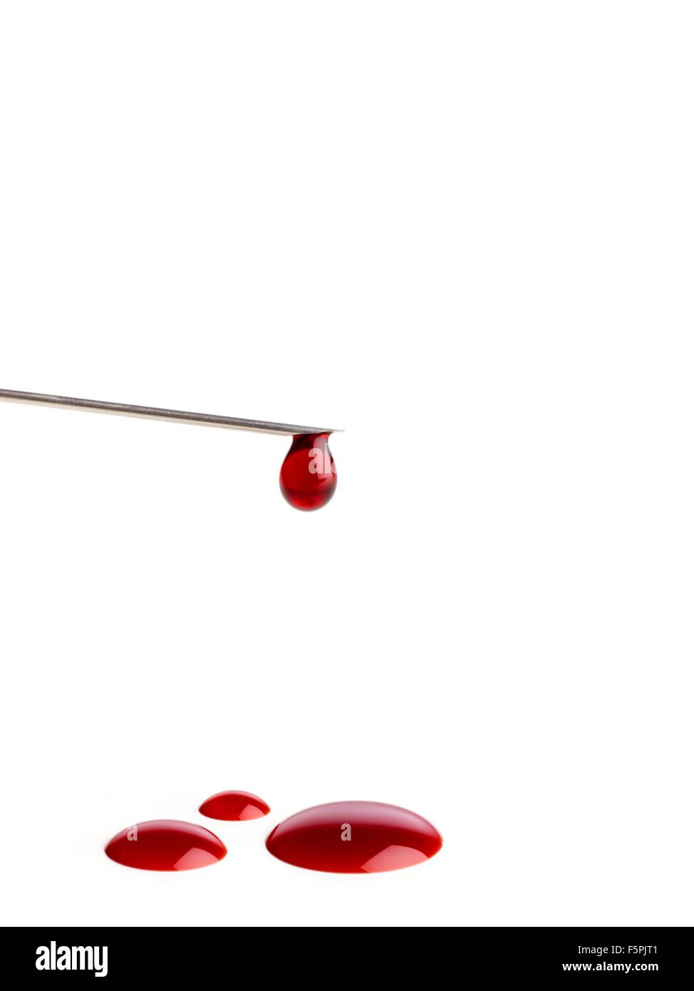 Blood dripping from the end of a syringe needle. Stock Photo
