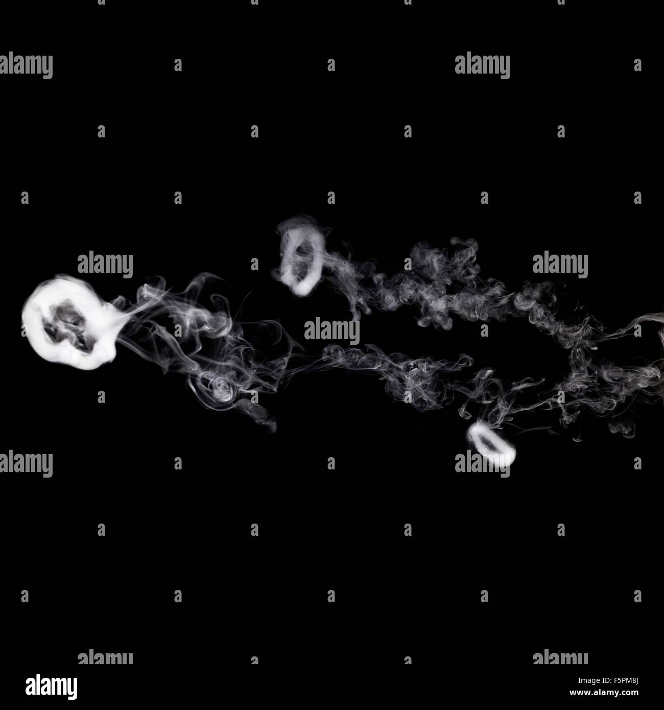 Smoke rings. This is a poloidal (rotating) vortex flow that is stable for considerable distances in still air. The rotating Stock Photo