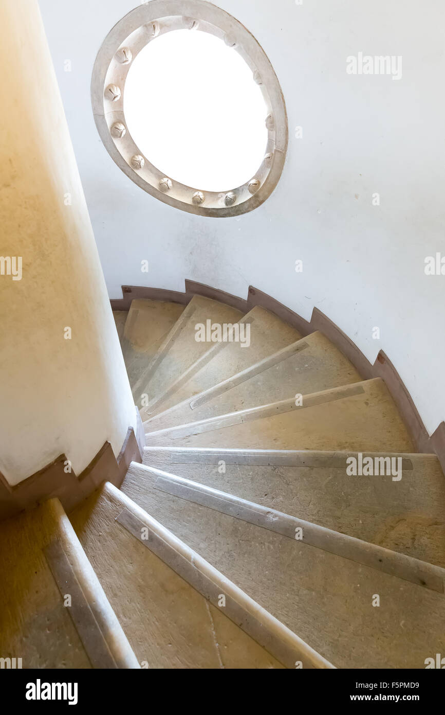 Spiral wooden stairs with a little round window Stock Photo
