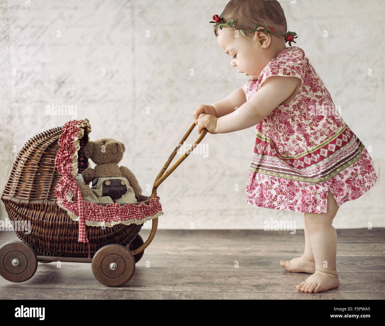 Little cute girl playing the toy carriage Stock Photo