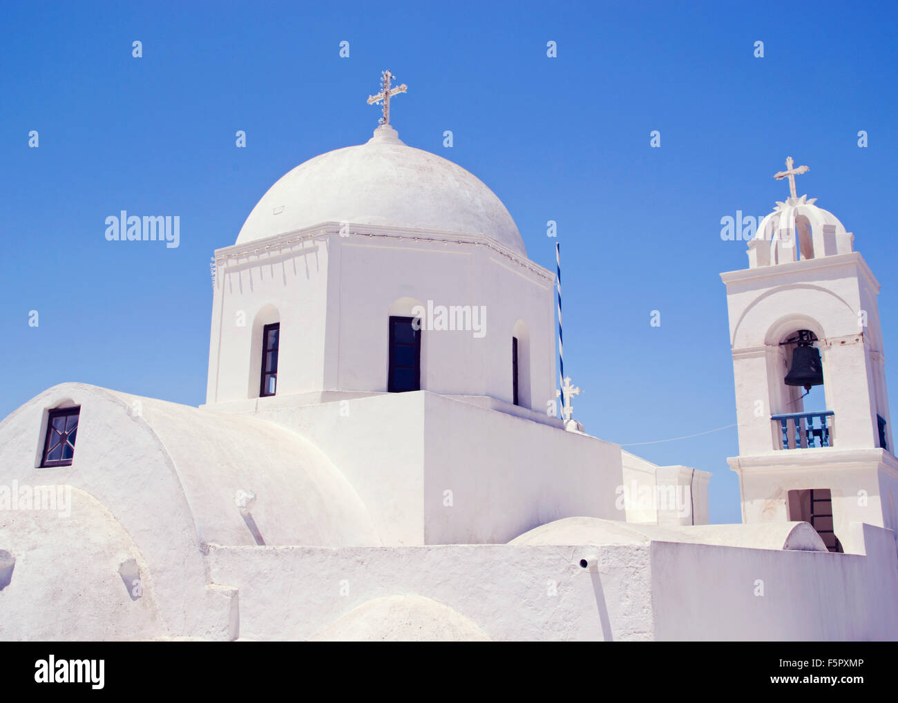 Traditional white painted church in Megalachori, Santorini, Greek Islands, against bright blue sky Stock Photo