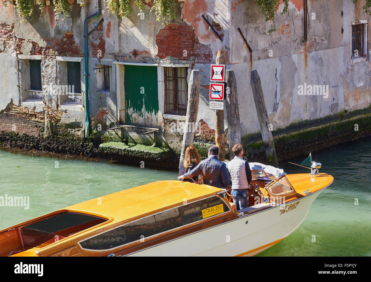 Water taxi (motoscafi) crossing a canal junction Cannaregio Venice Veneto Italy Europe Stock Photo