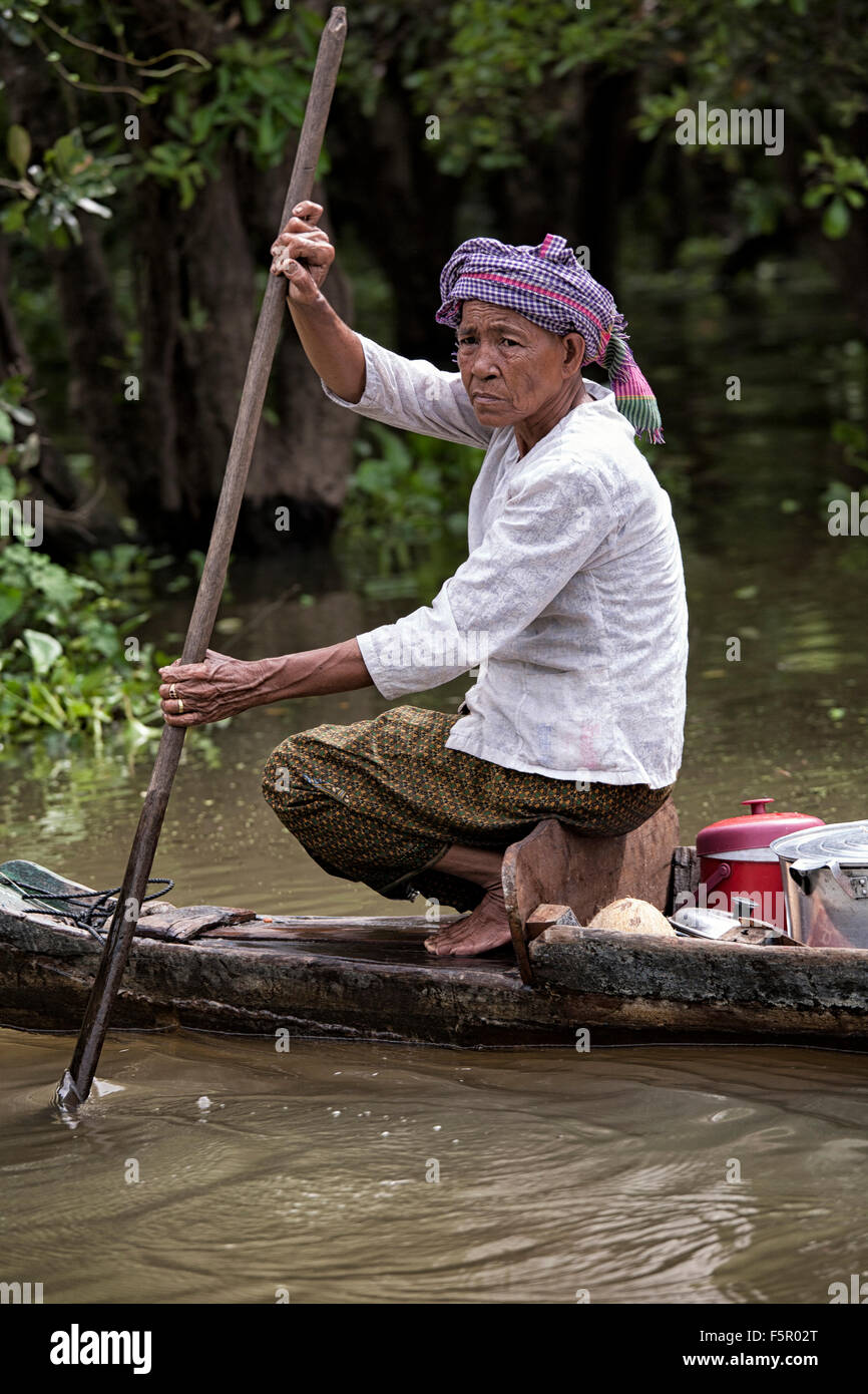 Cambodia boat people.  Woman navigating the waterways of the Tonle Sap river at the Siem Reap floating village Cambodia S. E. Asia Stock Photo