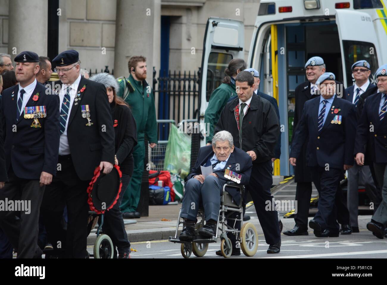 London, UK. 8th November, 2015. UK Remembrance Sunday. Older war veteran is assisted to his position in the parade with a wheelchair. Credit:  Marc Ward/Alamy Live News Stock Photo