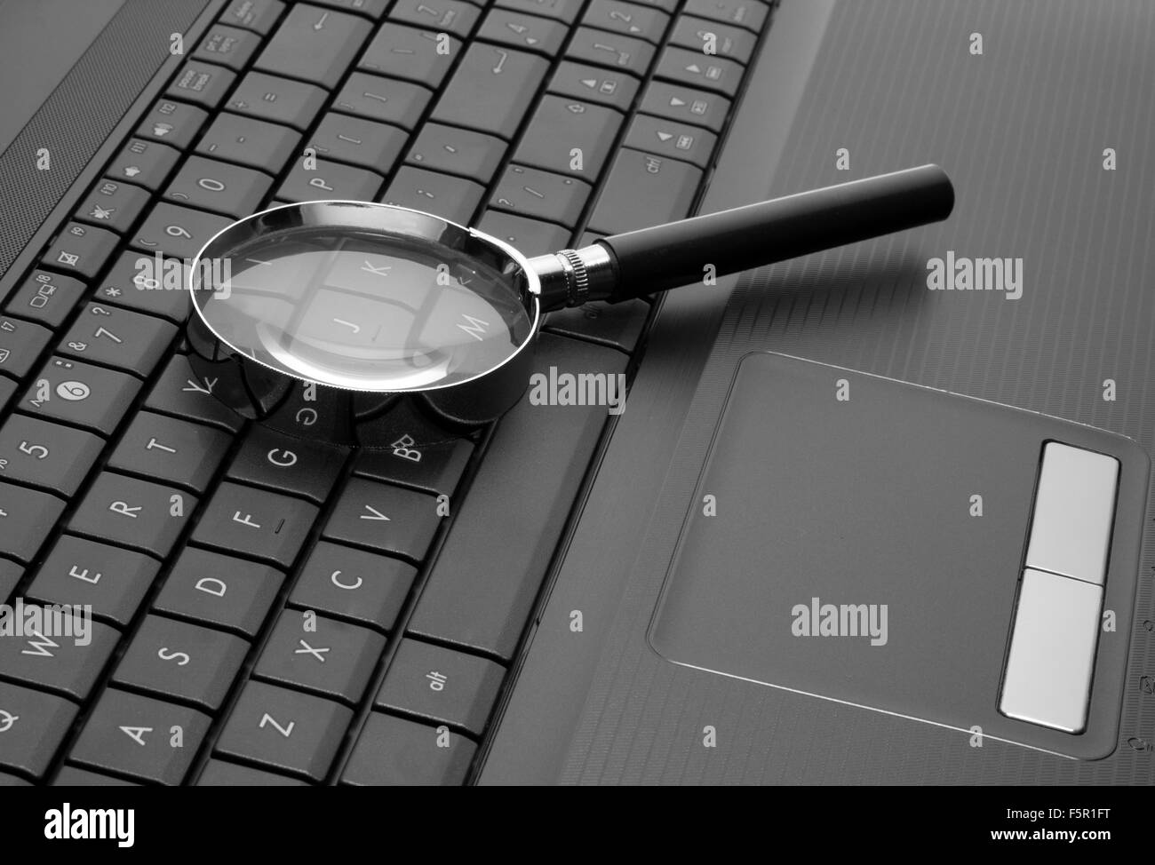 Magnifying glass on laptop computer keyboard Stock Photo Alamy