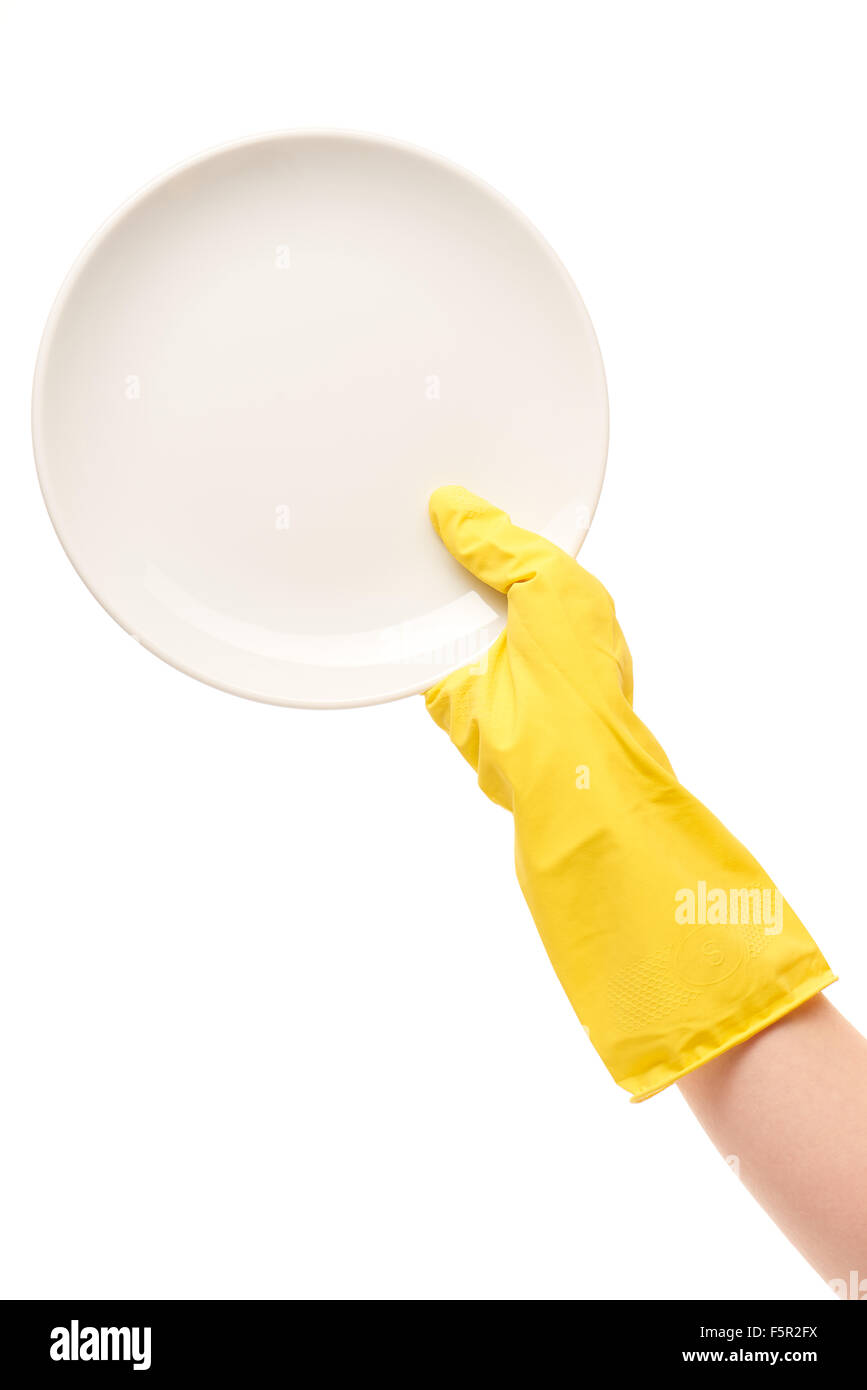 Close up of female hand in yellow protective rubber glove holding clean white plate against white background Stock Photo