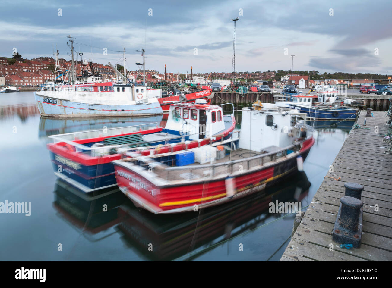 Fishing boats floating around in the harbour at Whitby, North Yorkshire