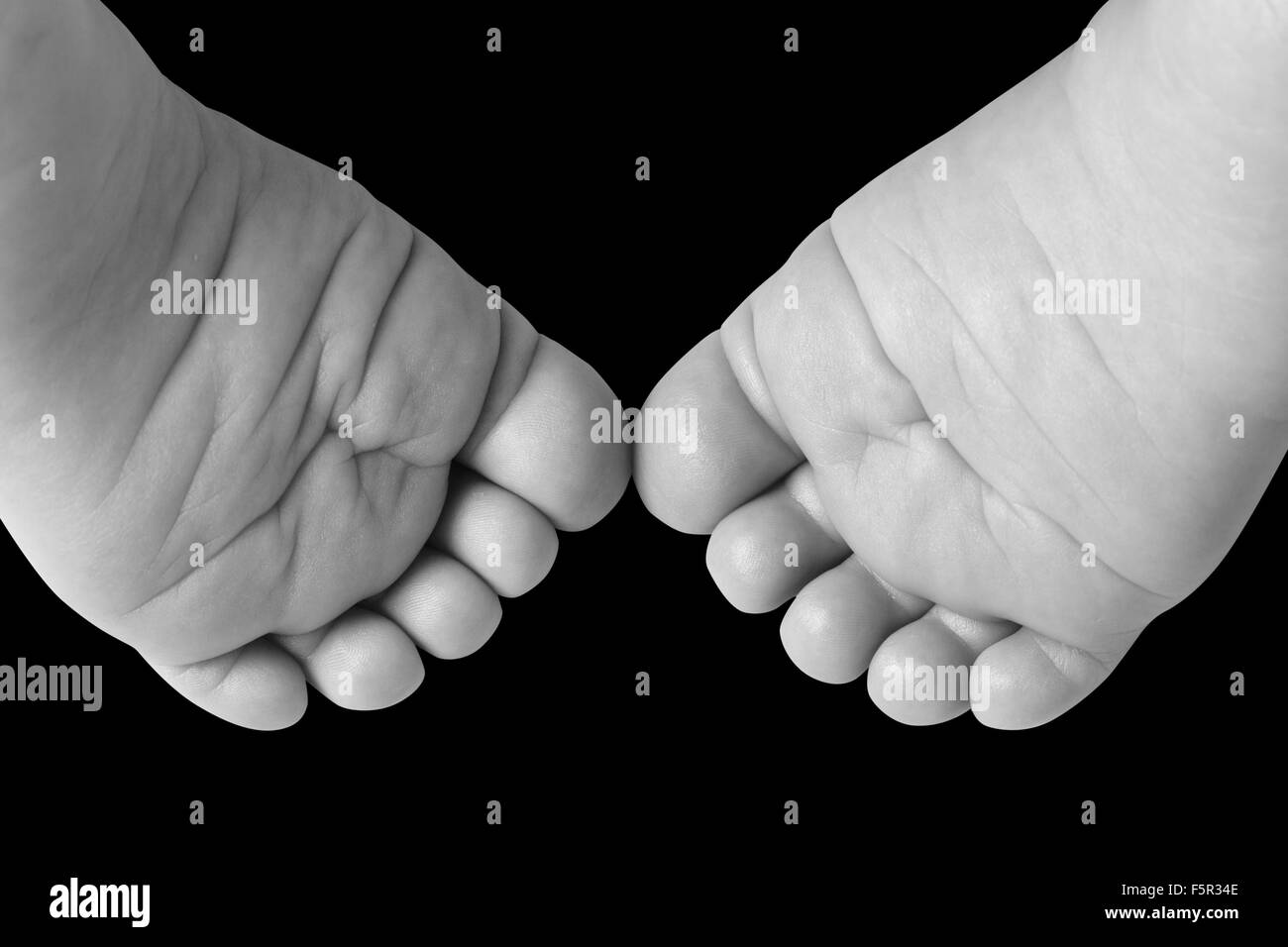 Closeup of newborn baby feet isolated on black Stock Photo Alamy