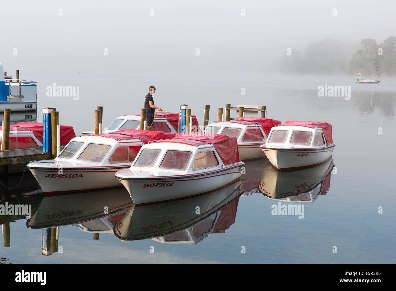 Hire boats being prepared on a misty morning on Lake Windermere Stock Photo