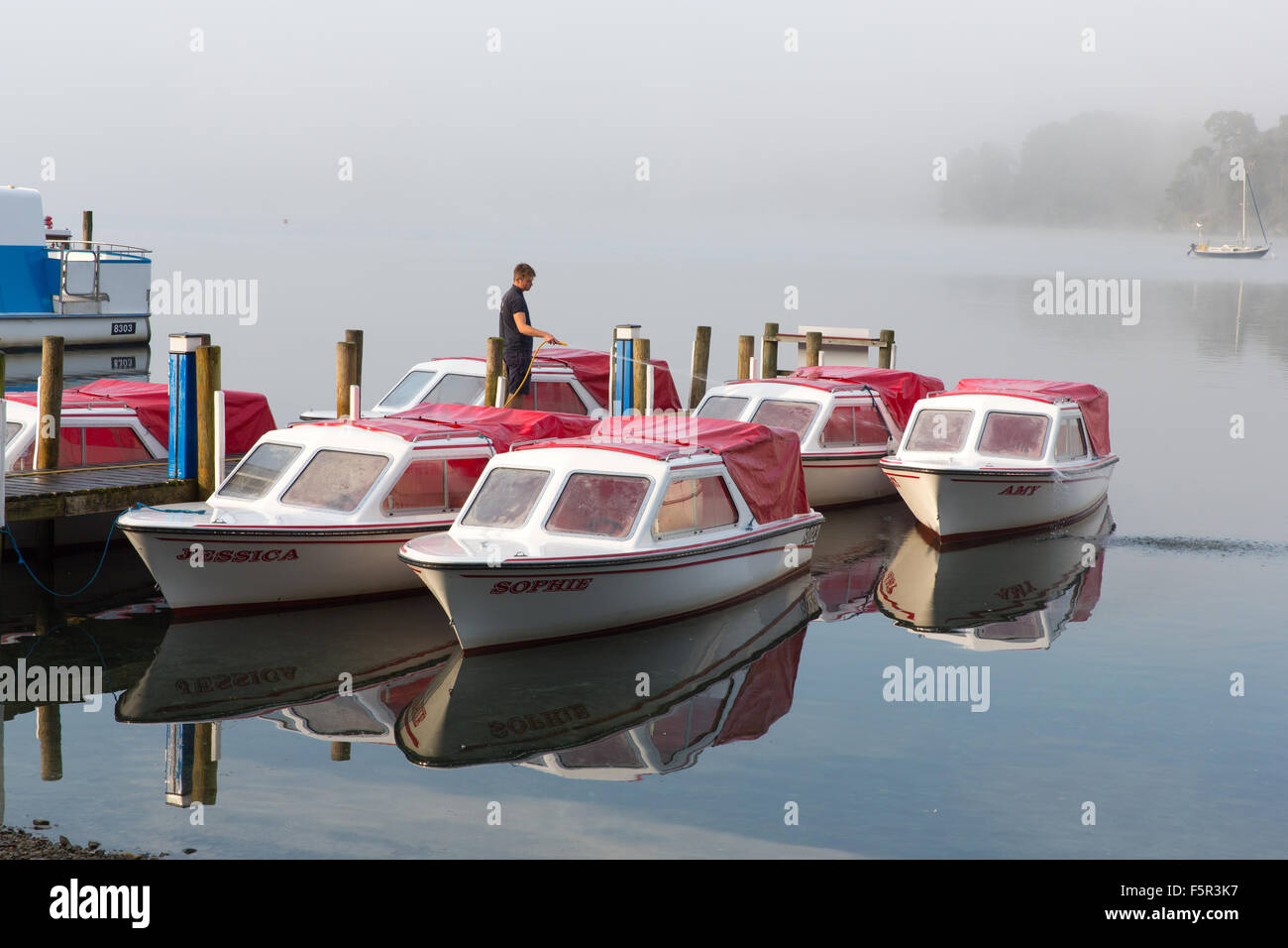 Hire boats being prepared on a misty morning on Lake Windermere Stock Photo