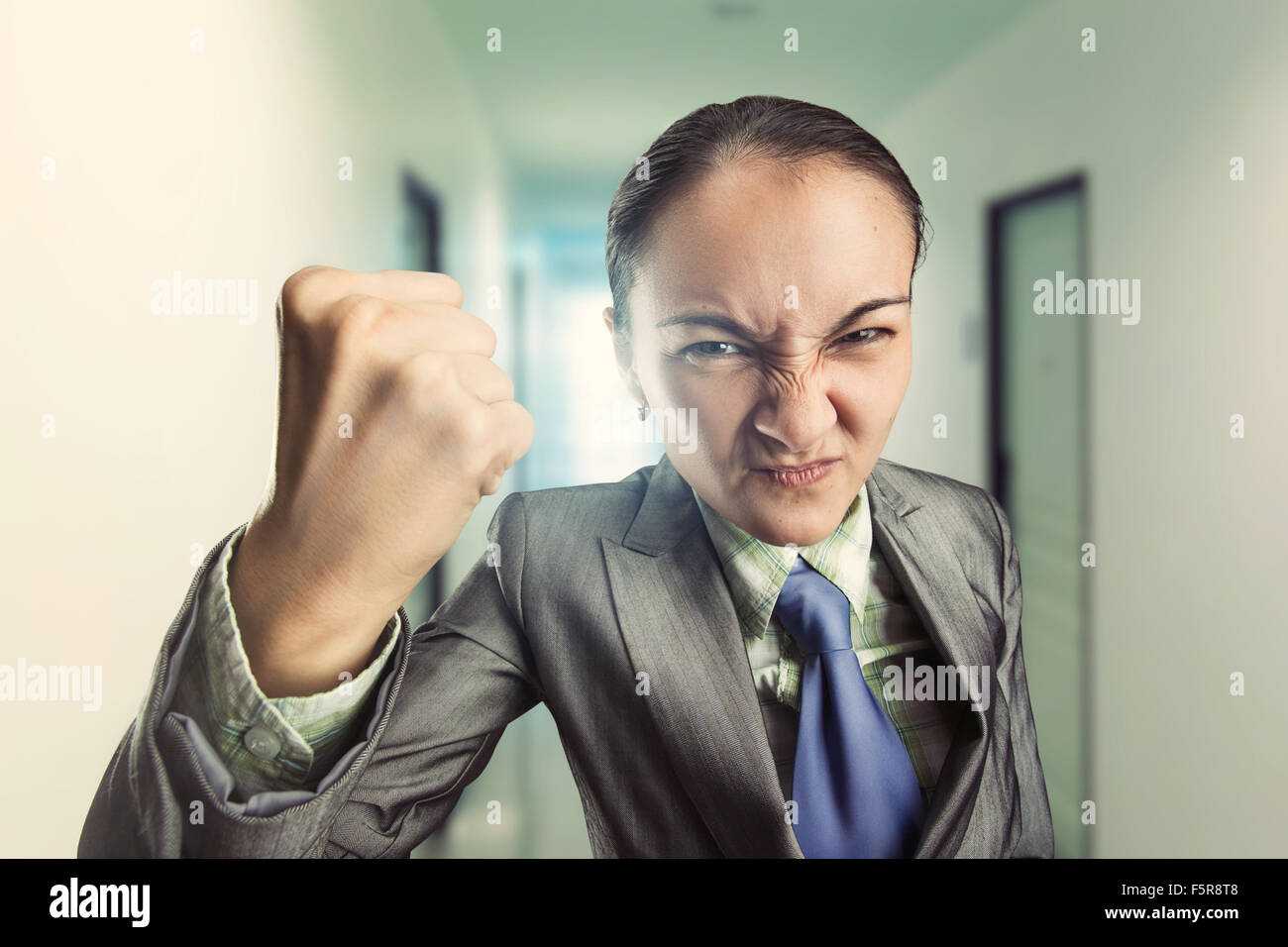 Angry irritated woman clenching her fist in the office Stock Photo