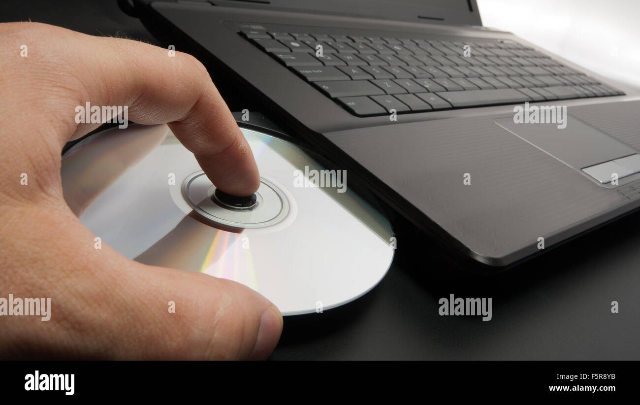Loading CD DVD into laptop Stock Photo Alamy