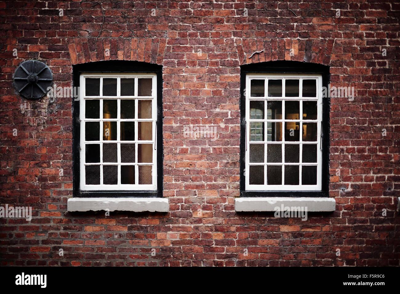 Two windows and a support in red brickwork Stock Photo