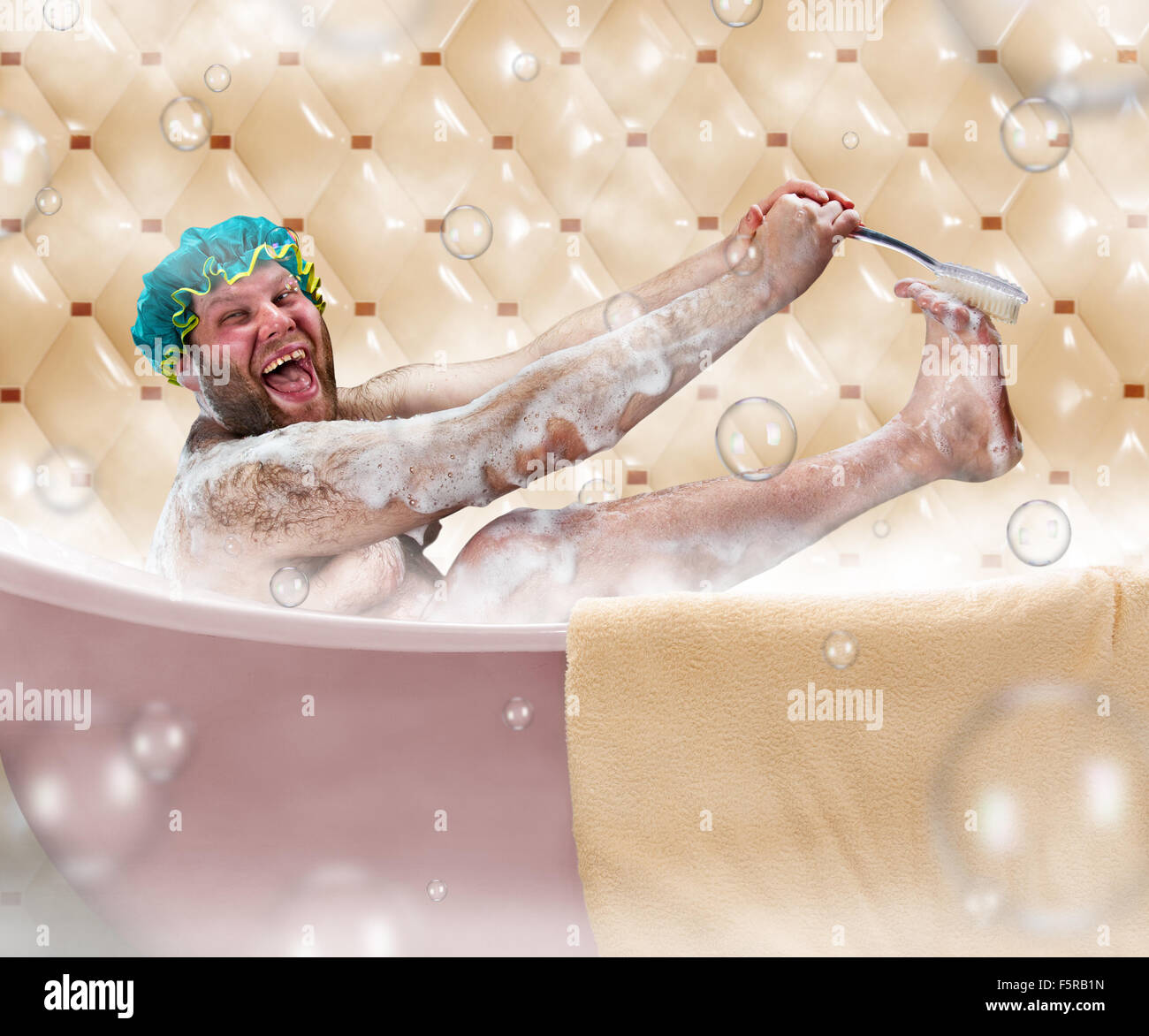 Bizarre ugly man washing his leg in a bath Stock Photo