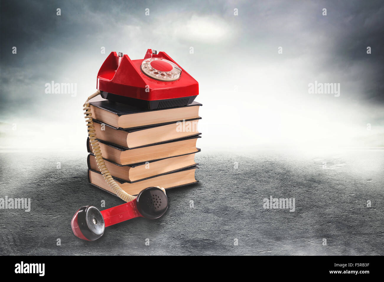 Vintage red telephone on a misty road Stock Photo