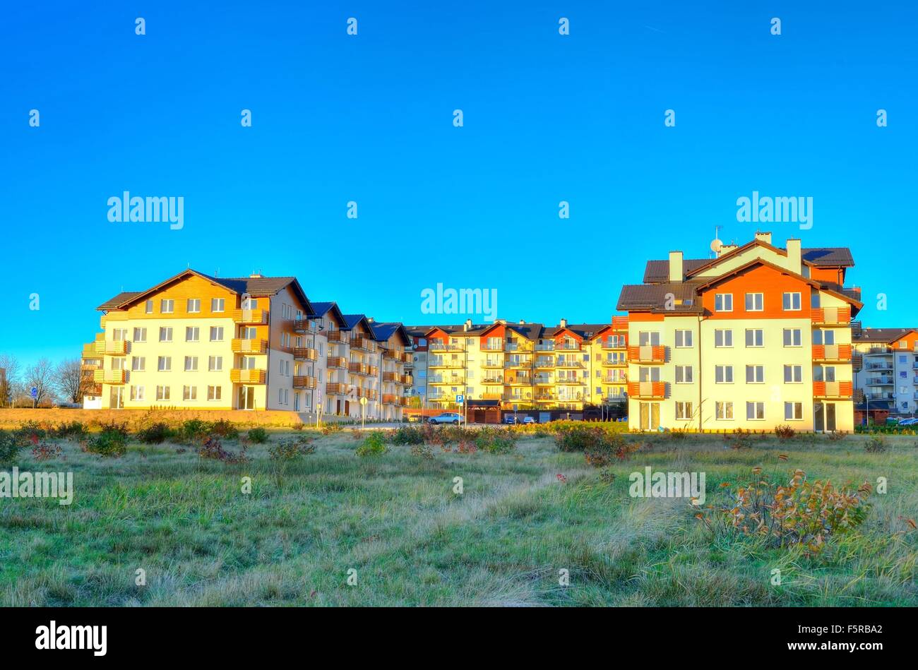 New housing estates. Public view of newly built block of flats in green area. Stock Photo