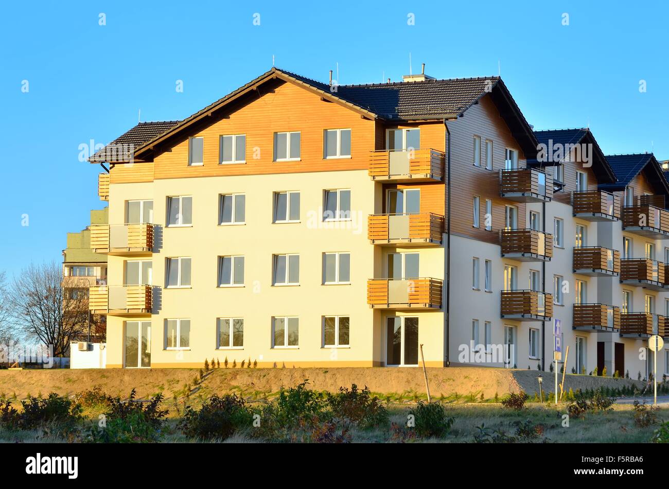 New housing estates. Public view of newly built block of flats in green area. Stock Photo