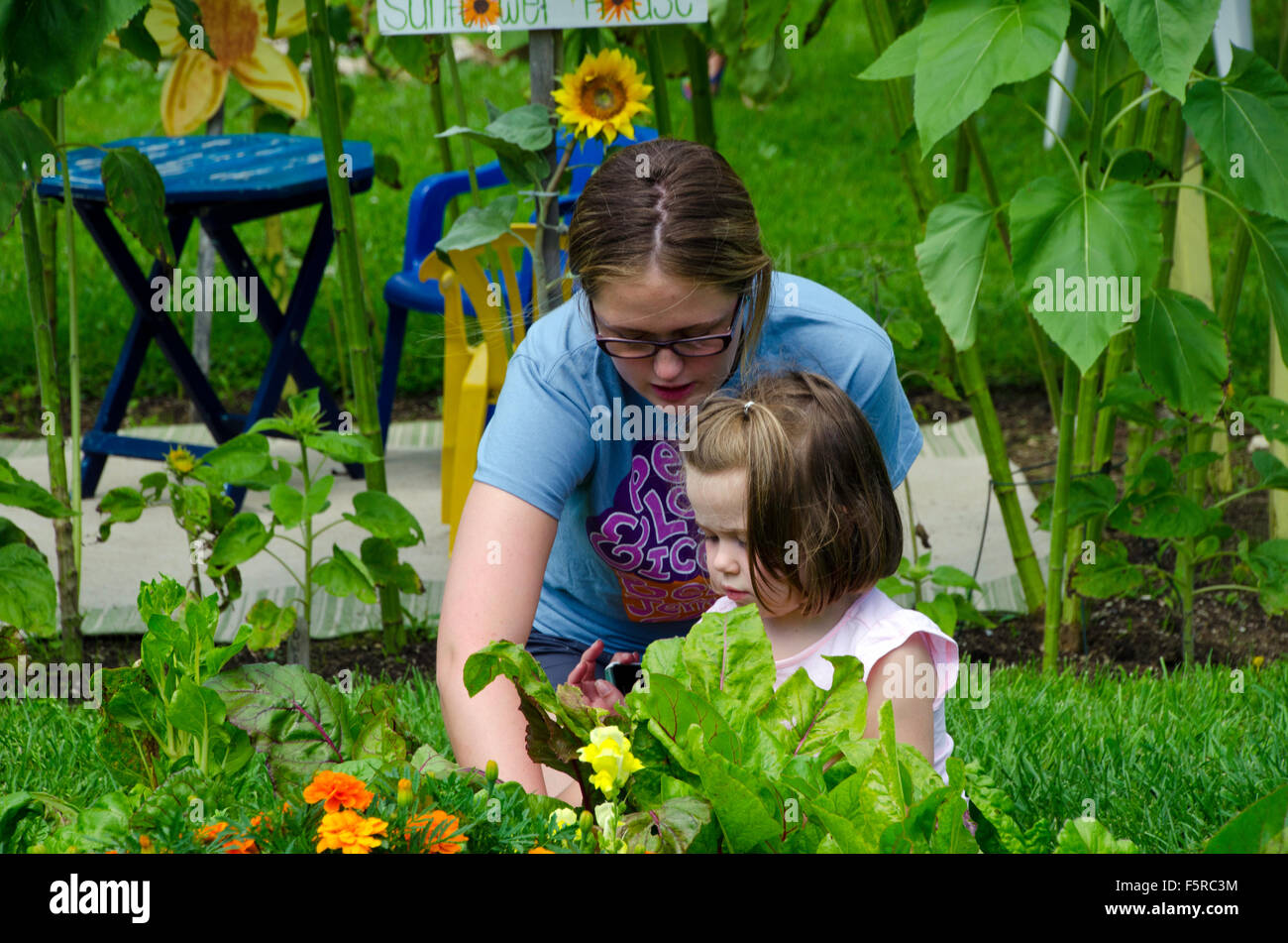 Young woman teaches girl in summer camp, Yarmouth Community Garden, Maine Stock Photo
