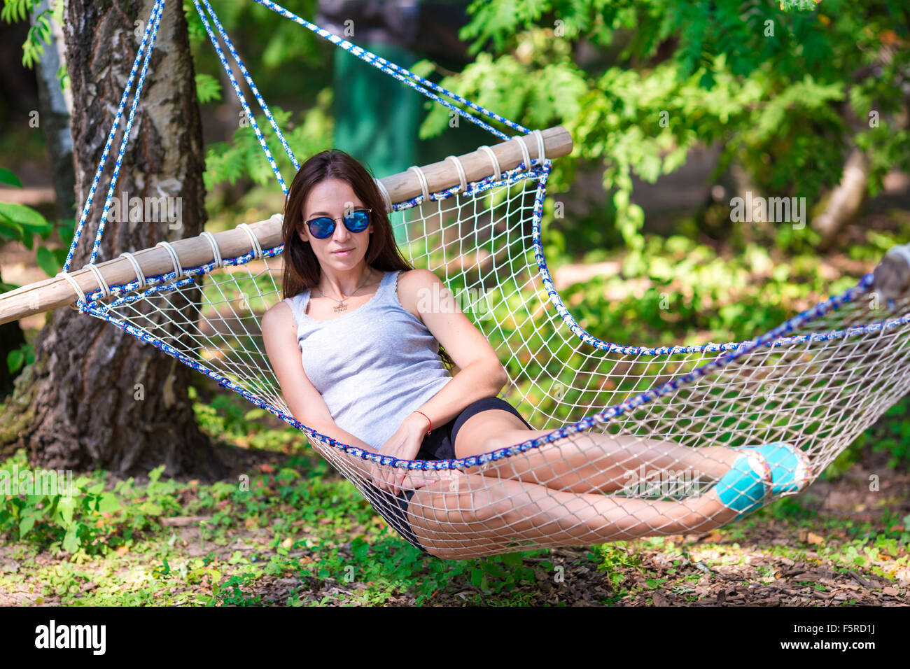 Happy young woman relaxing in hammock Stock Photo - Alamy