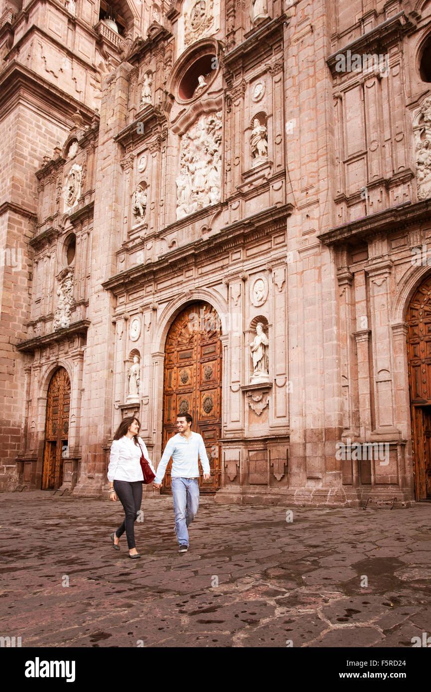 Young couple walking in front of the cathedral in Morelia, Michoacan, Mexico. Stock Photo