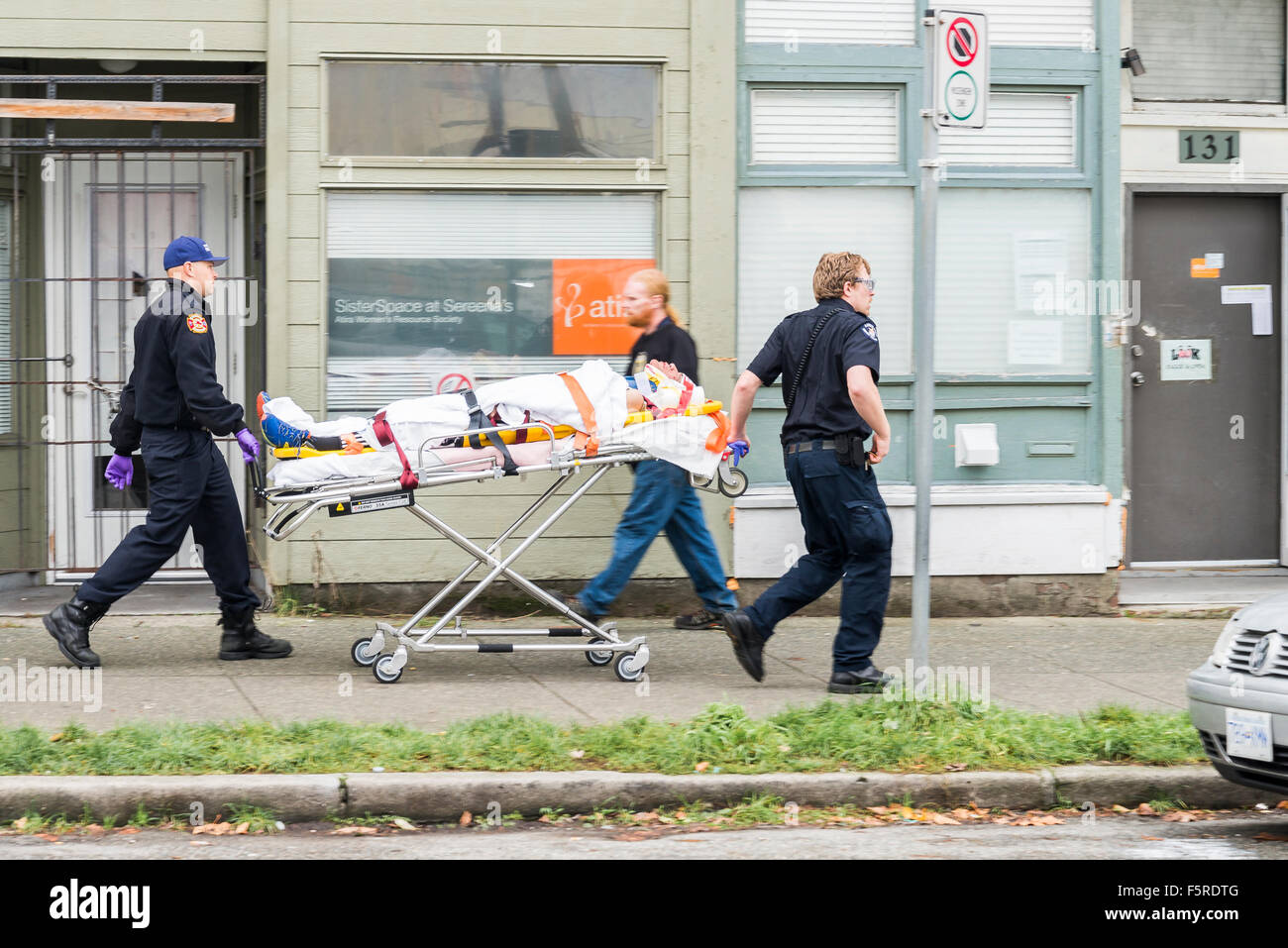 Emergency paramedic attendants with man on stretcher, DTES, Vancouver, British Columbia, Canada Stock Photo