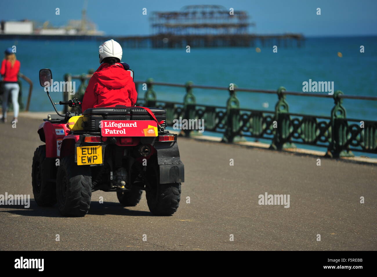 A lifeguard rides along the Brighton seafront on a quad bike. Stock Photo