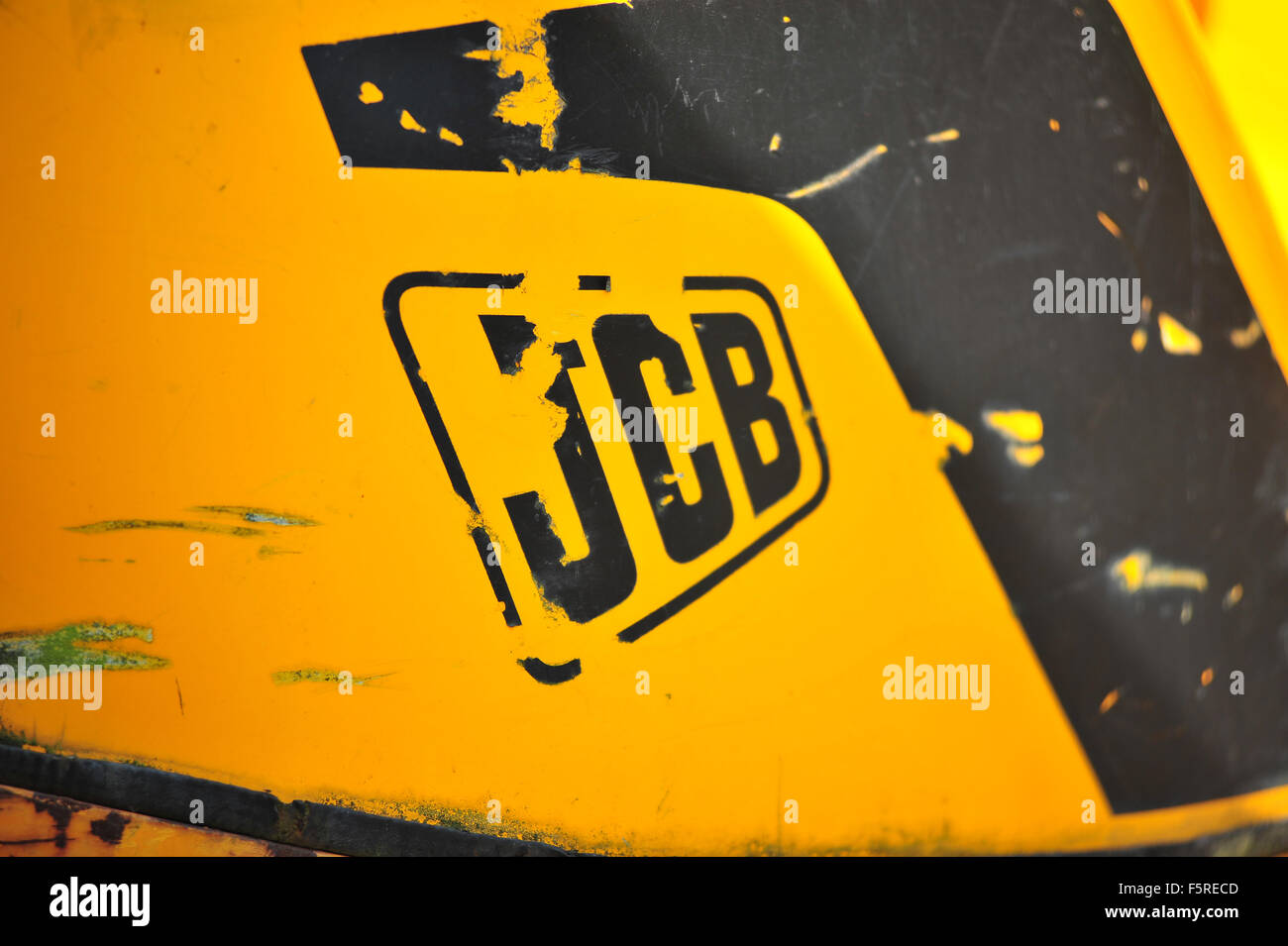 The side of a worn JCB digger in a garden in the UK. Stock Photo