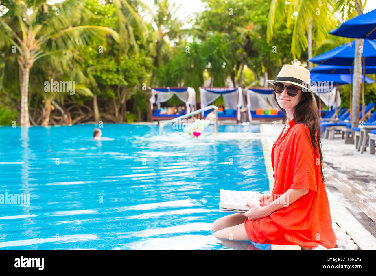 Young girl reading book relaxing in swimming pool Stock Photo - Alamy